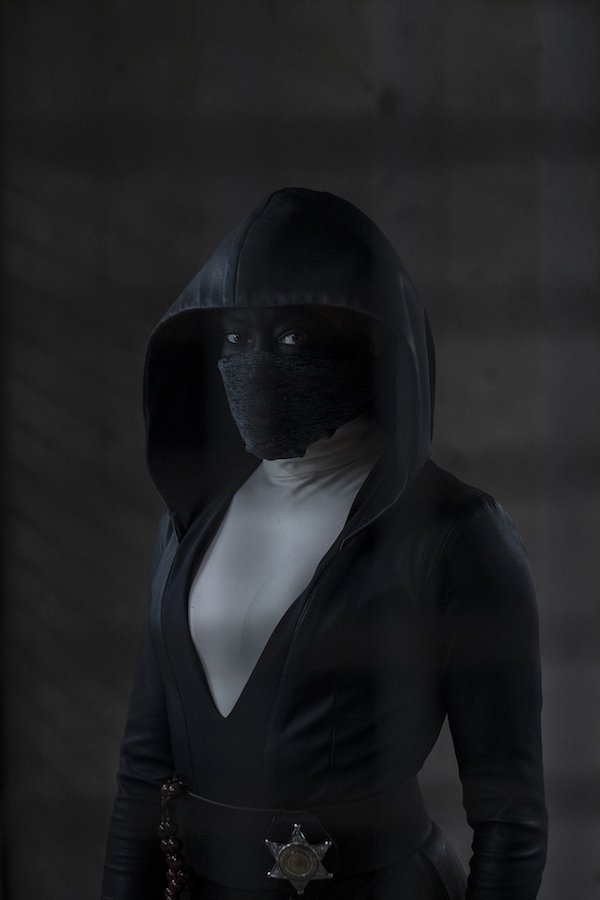 Il personaggio di Angela Bar interpretato da Regina King. Indossa un vestito nero con cappuccio e una maschera, anch'essa nera