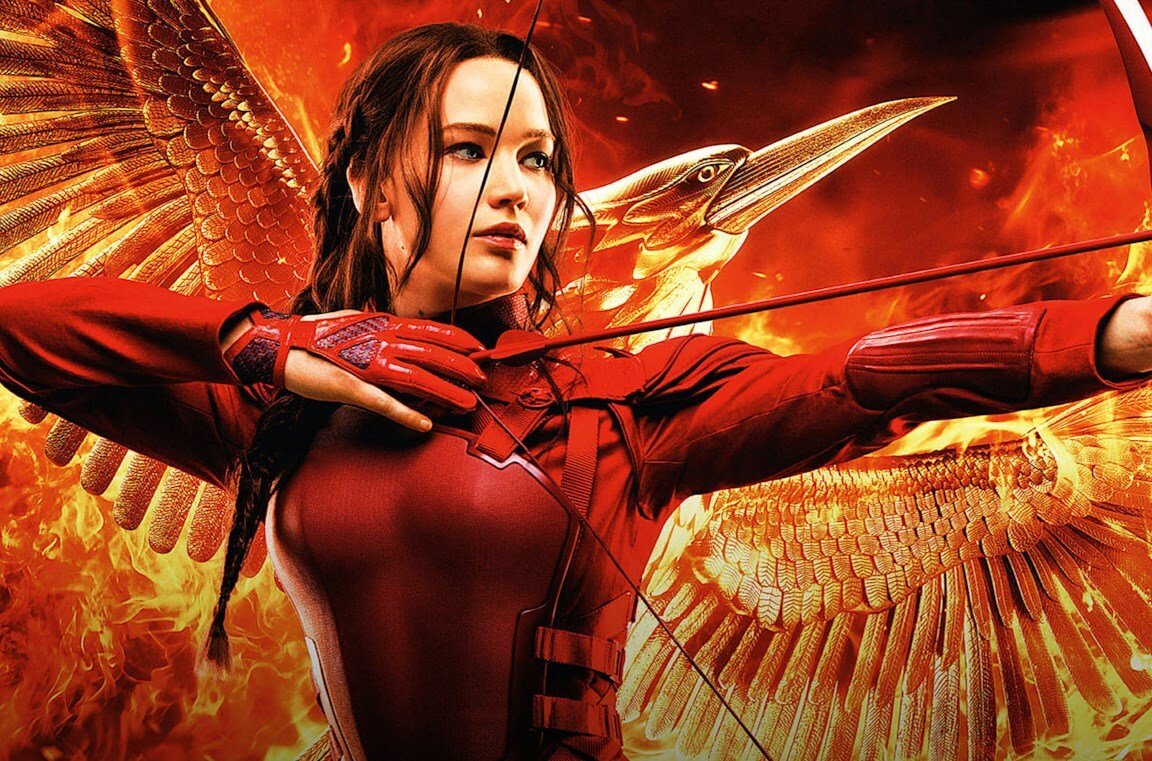 Katniss impugna arco e frecce su sfondo rosso