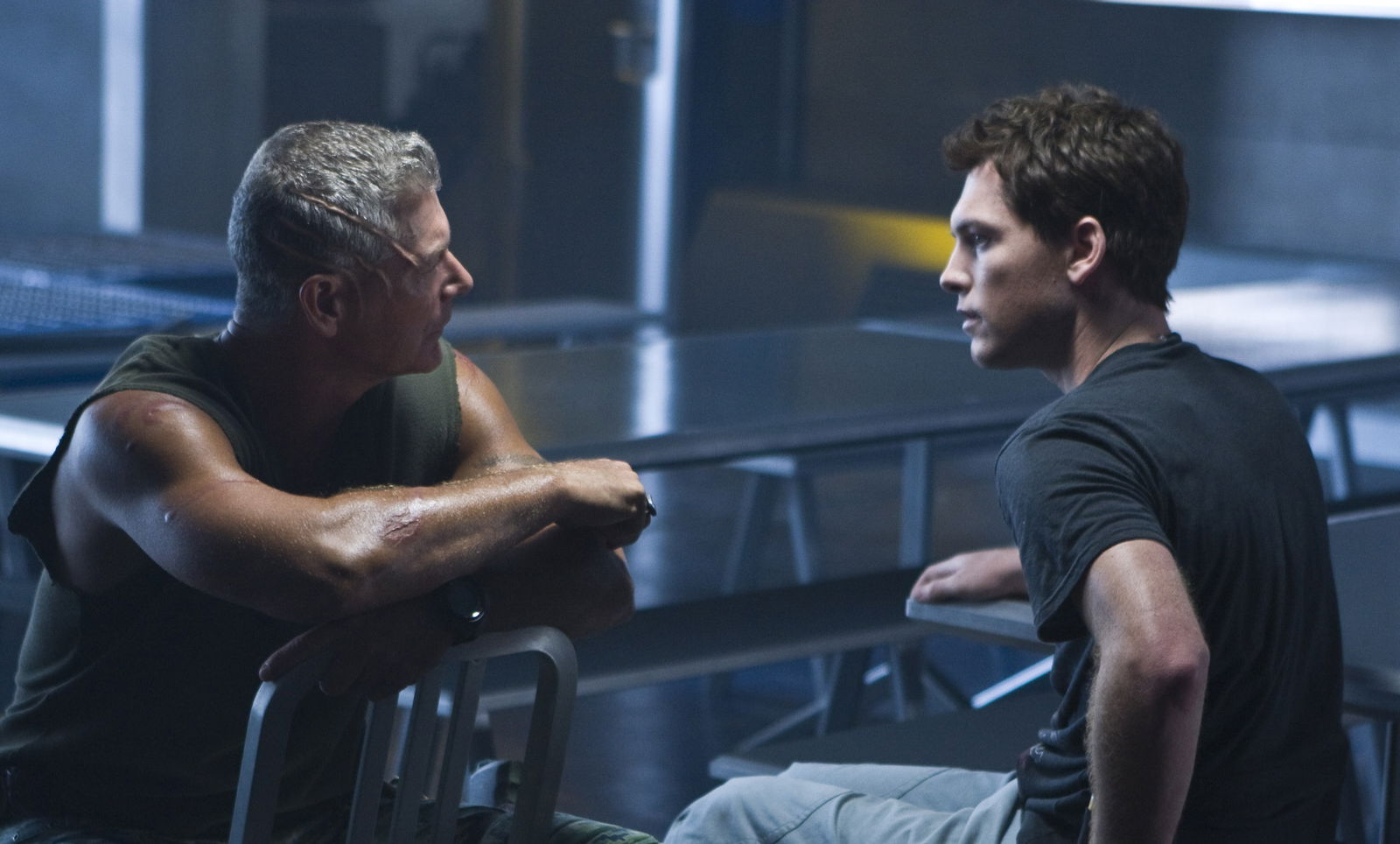 Clicca per vedere l'immagine originale Jake (Sam Worthington) e il colonnello Quaritch (Stephen Lang) parlano, seduti nella sala mensa della base