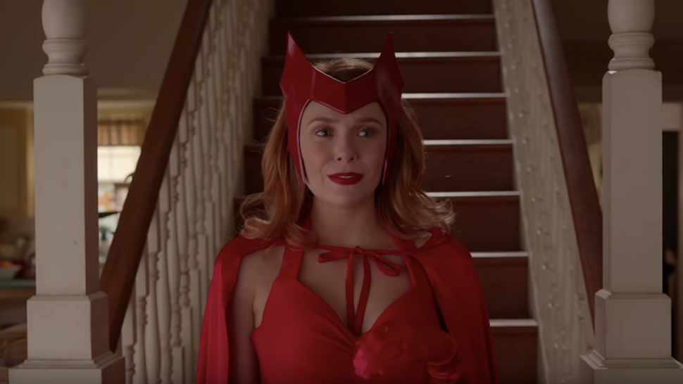Wanda scende le scale della propria abitazione, con un costume rosso