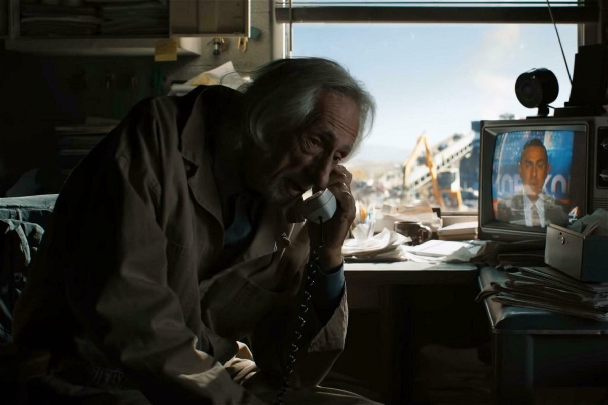 Il Vecchio Joe parla al telefono nella sua discarica, con una TV sullo sfondo
