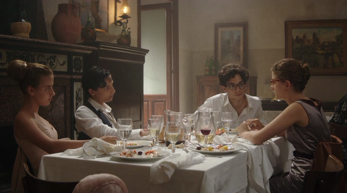 Lenù al tavolo con Alfonso e Nino al matrimonio di Lila