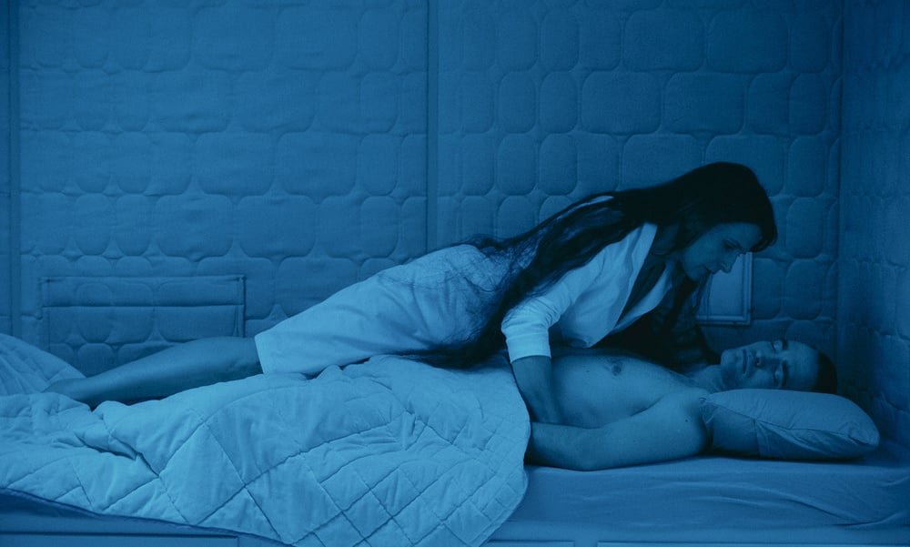 Robert Pattinson (addormentato) e Juliette Binoche in una scena del film