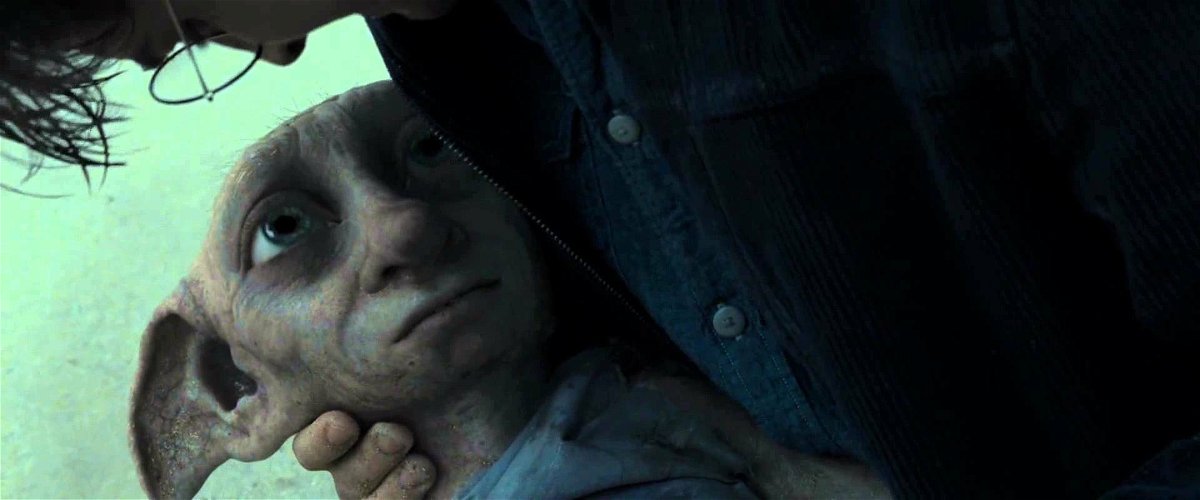 Dobby muere en los brazos de Harry, en una playa.