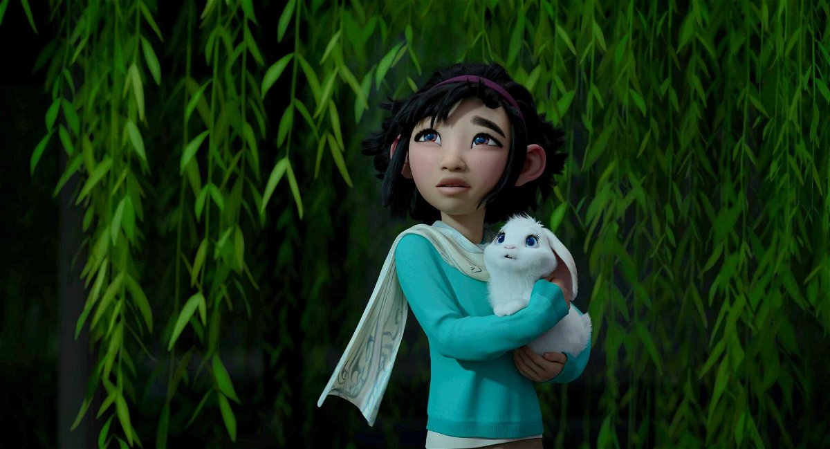 Mezza figura di Fei Fei con in braccio il suo coniglio Bungee