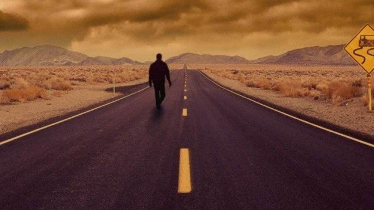 Un uomo cammina solo in una strada deserta in un'immagine promozionale de L'ombra dello scorpione (1994)