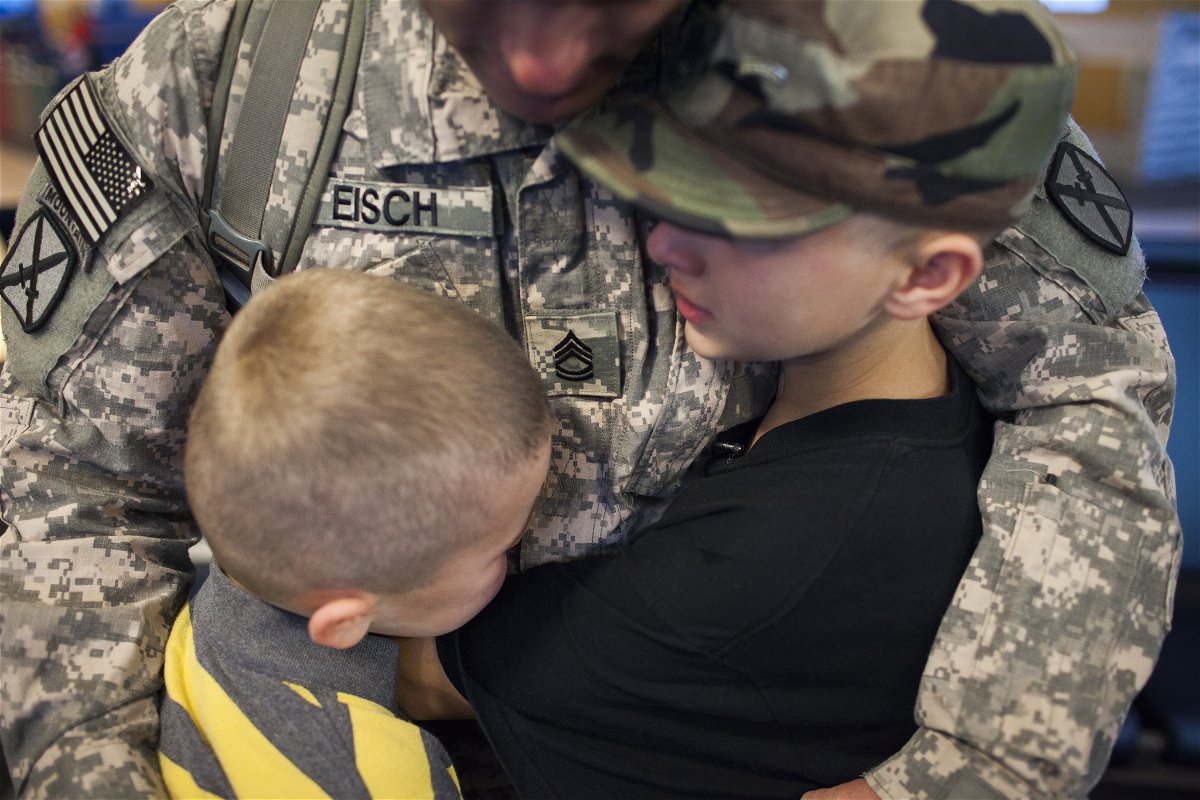 Il sergente abbraccia i suoi due figli