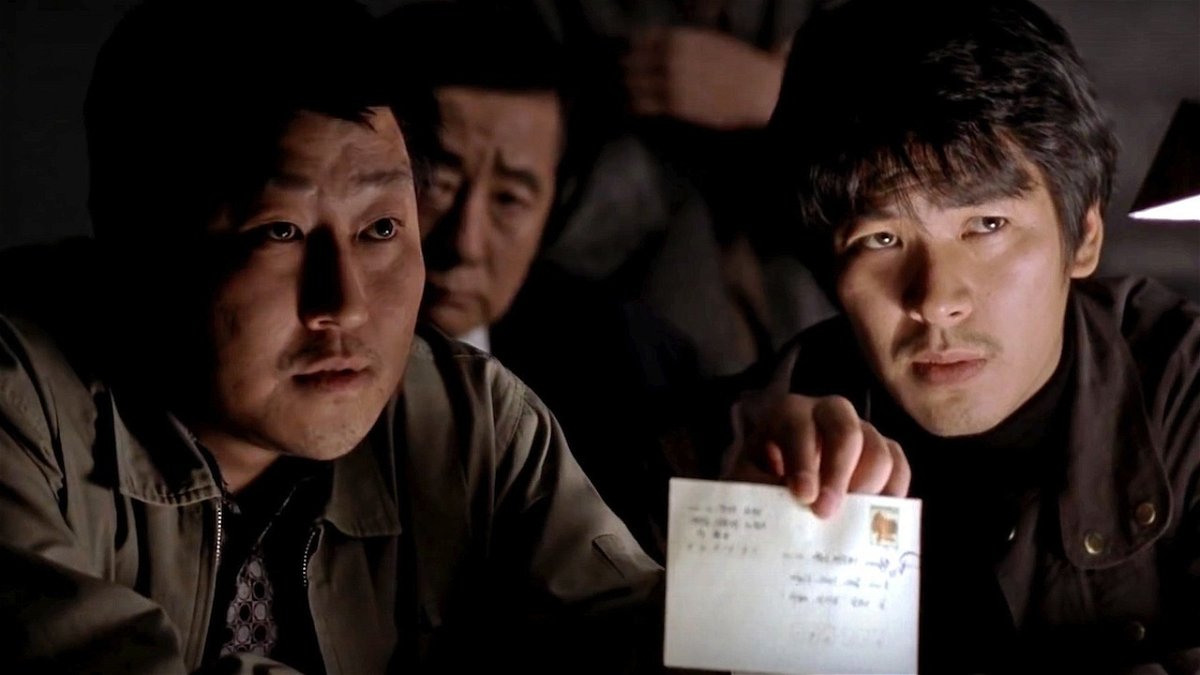 I detective protagoinisti di Memorie di un assassino mostrano una lettera