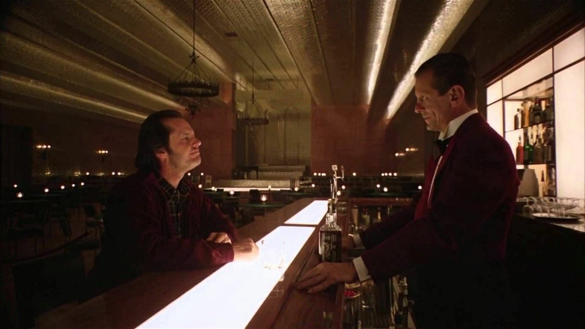 Il protagonista discute con Lloyd, il barman, nella Gold Room