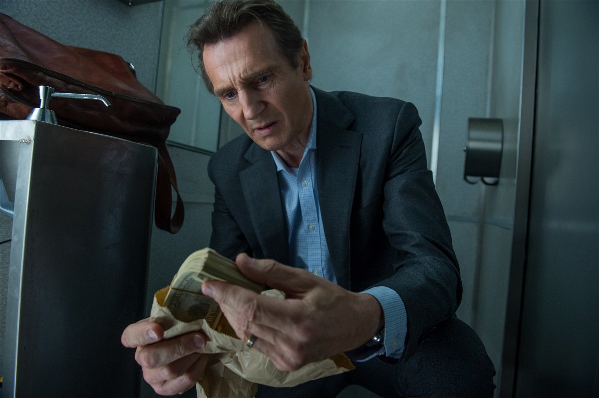 Liam Neeson osserva una mazzetta di dollari