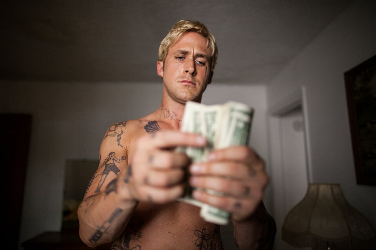 Ryan Gosling a torso nudo mentre conta i soldi in una scena del film