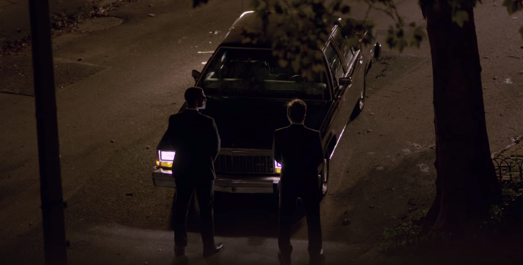 Men in Black: International, la connessione con la trilogia originale Nella notte, due agenti dei Men in Black davanti una auto