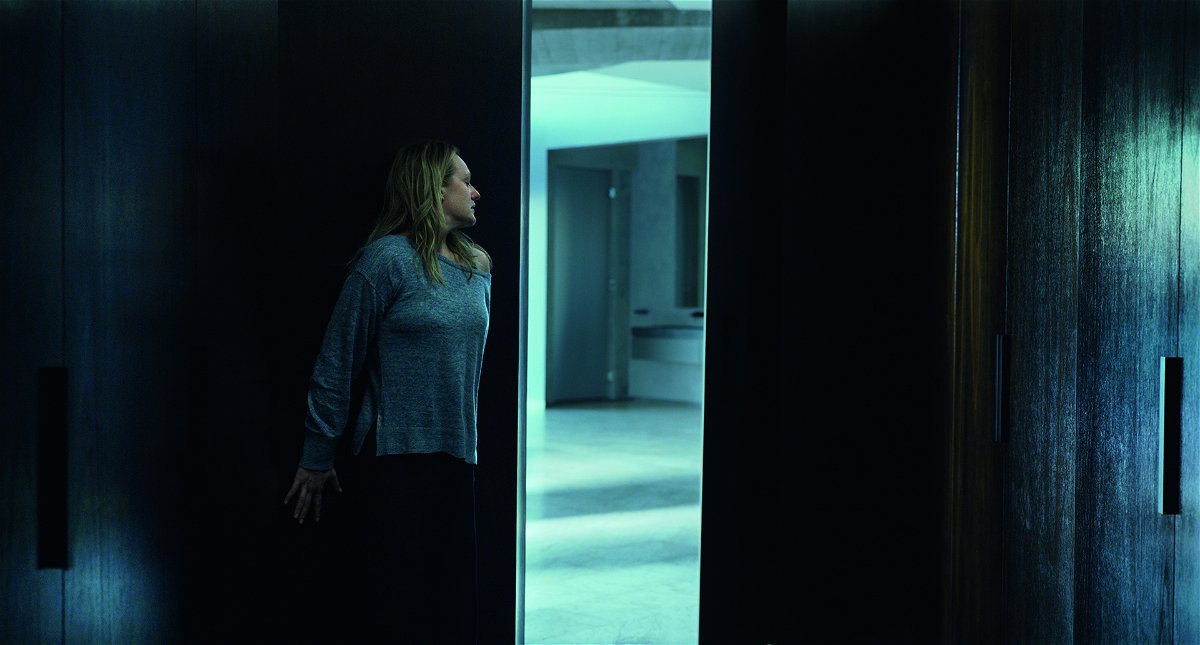 Elisabeth Moss nascosta contro una porta aperta