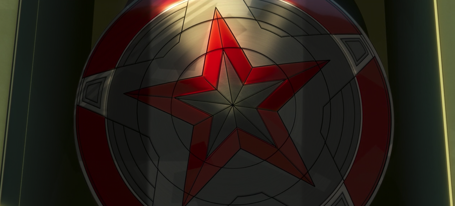 Click para ver la imagen original Un escudo como el del Capitán América pero con diferentes colores, rojo y gris.
