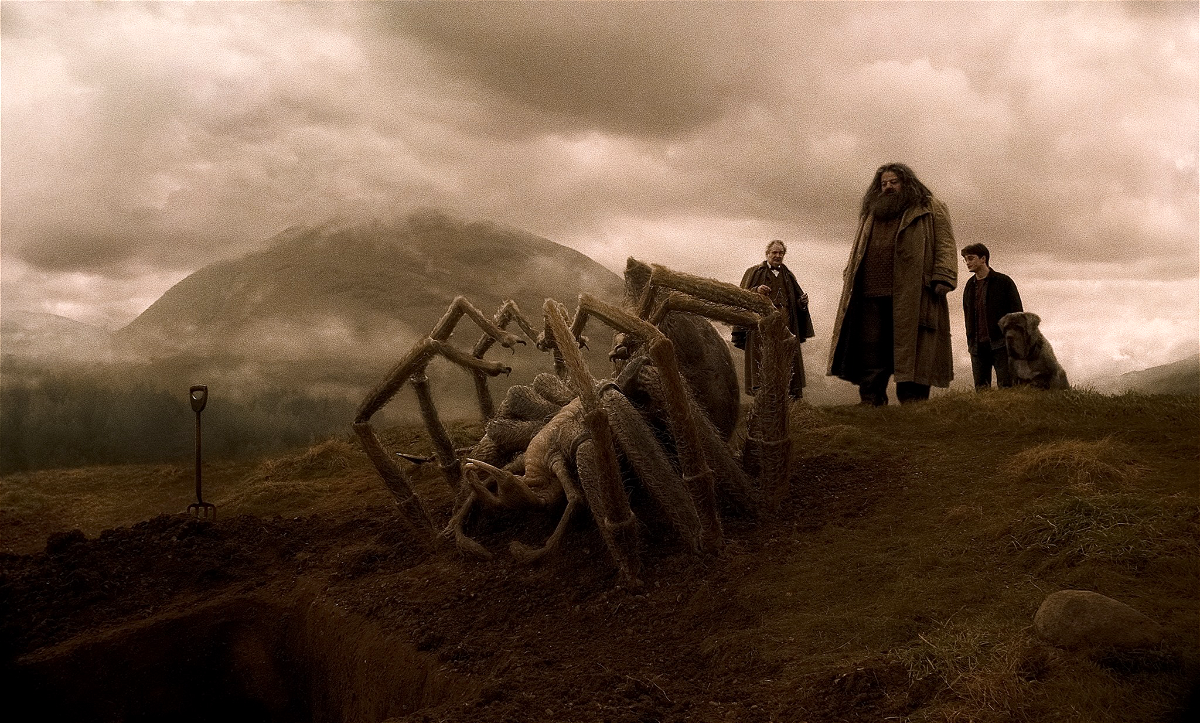 Slughorn, Harry y Hagrid asisten al funeral de Aragog frente a su cadáver gigante