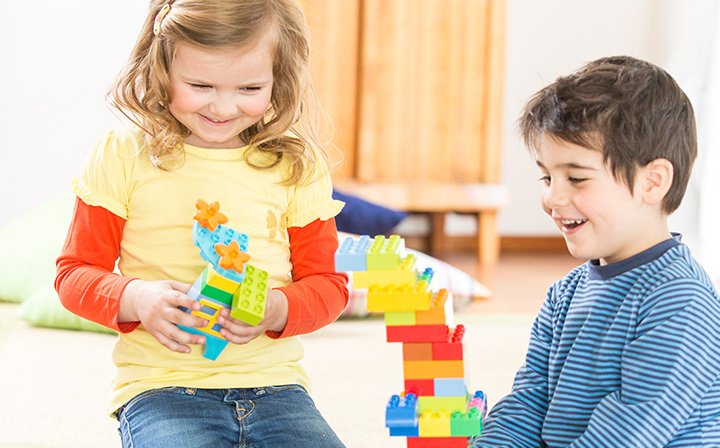 Due bambini giocano con i mattoncini LEGO