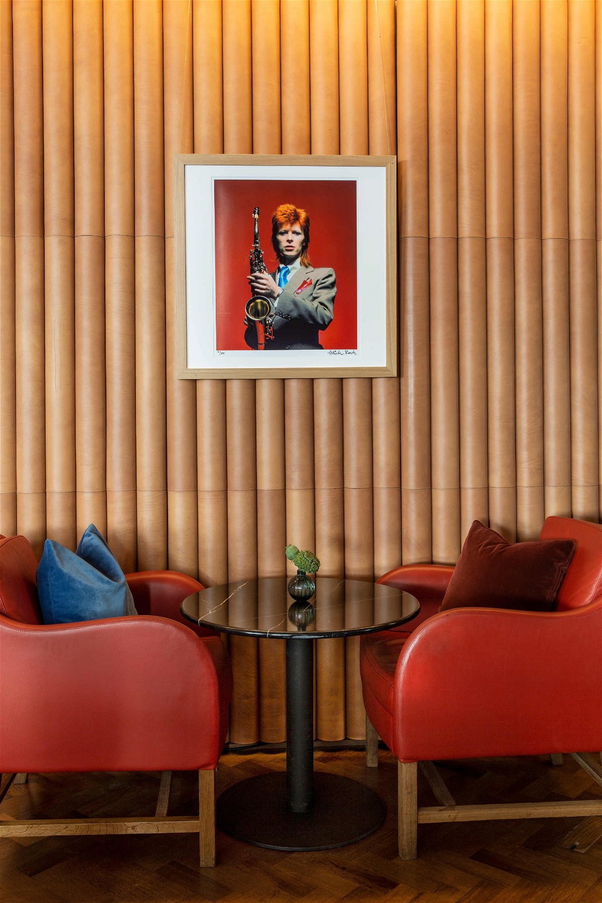 Due poltrone, un tavolino e una foto di David Bowie appesa alla parete del bar Ziggy's di Londra