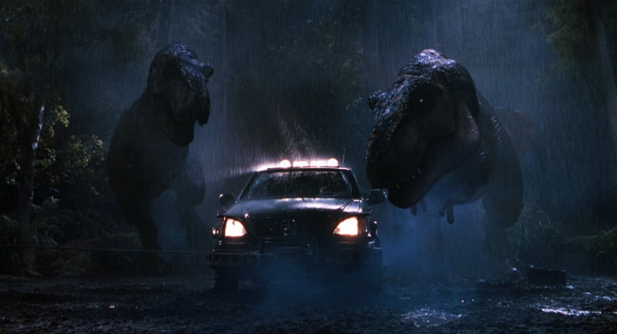 Los dos T-Rexes atacan el auto de Eddie