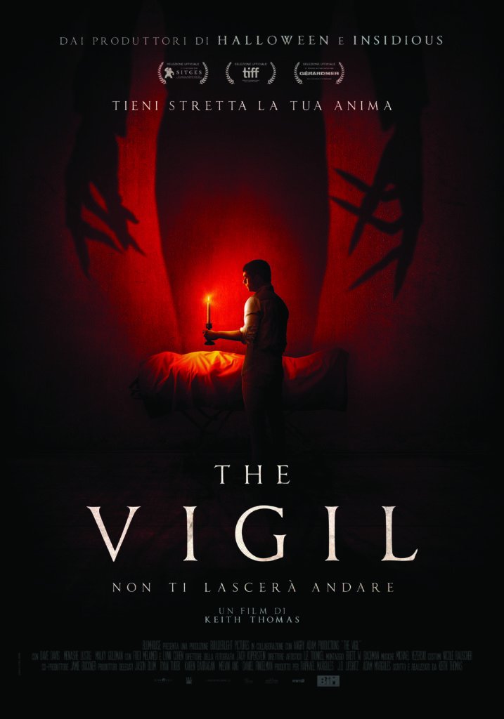 Un ragazzo tiene una candela in mano nel poster di The Vigil