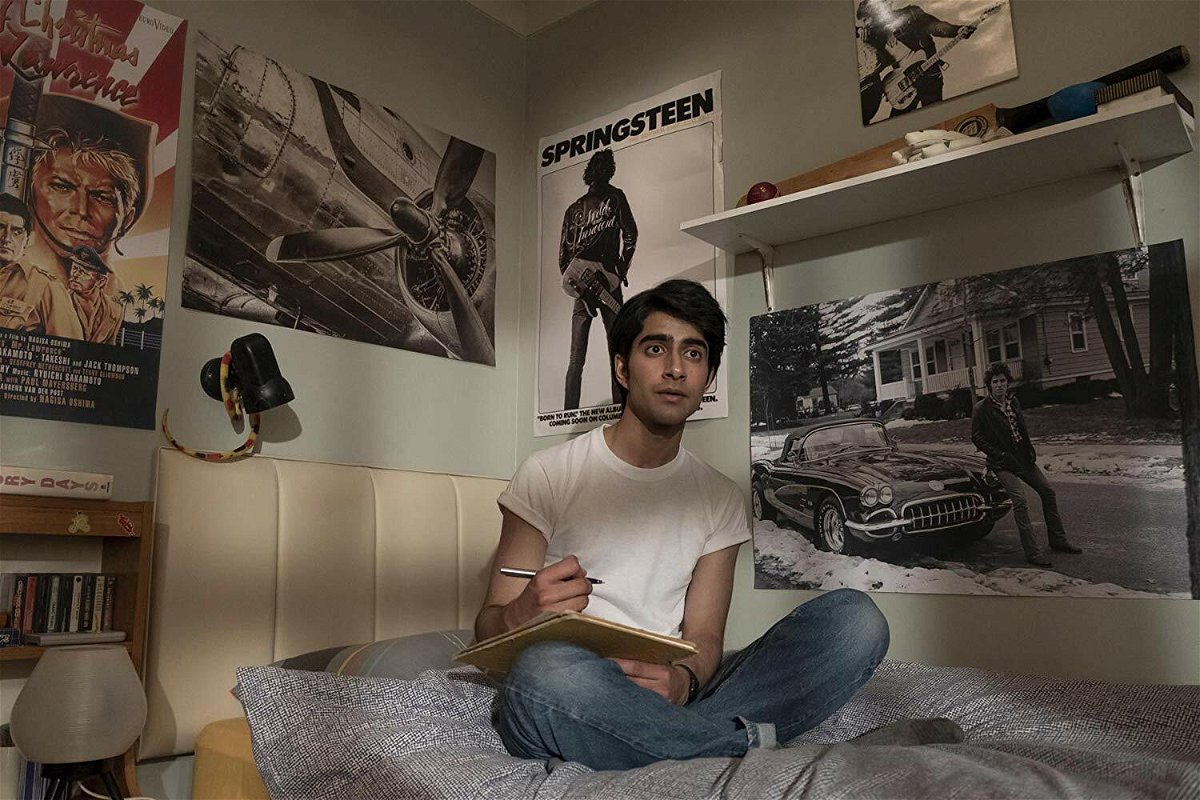 Viveik Kalra seduto sul letto in una scena di Blinded by the Light
