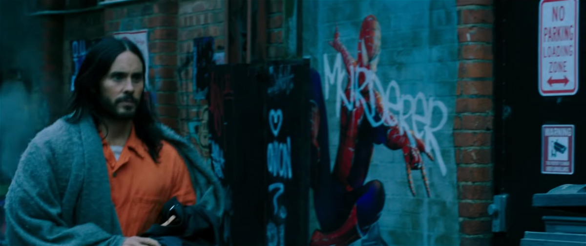 Michael Morbius in primo piano; alle sua spalle un murales dedicato a Spider-Man