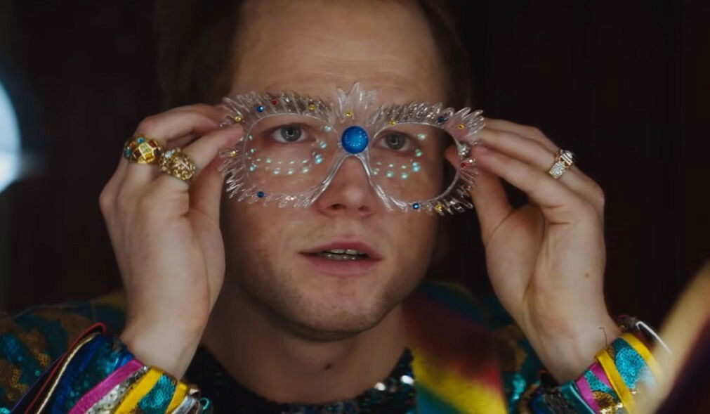 Clicca per vedere l'immagine originale Elton John indossa gli occhiali e si prepara a iniziare un'esibizione