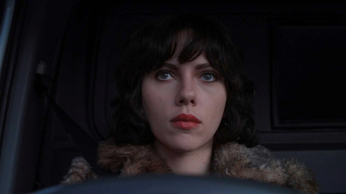 Un primo piano di Scarlett Johansson bruna e seduta in auto in una scena di Under the Skin